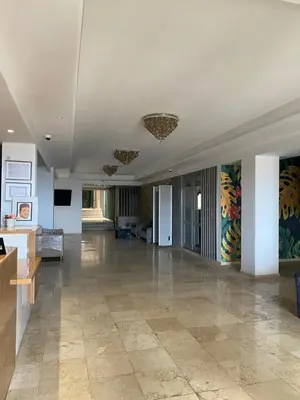 a large room with a lobby with a couch and tables at Hotel Azur in Casablanca