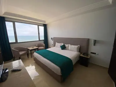 a hotel room with a bed and a large window at Hotel Azur in Casablanca