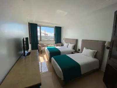 a hotel room with two beds and a window at Hotel Azur in Casablanca