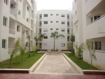 a courtyard of a building with palm trees and buildings at Jnane Eddalya in Bouznika