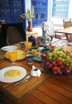 a wooden table with food and fruit on it at Riad Des Plages in Bouznika
