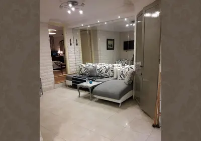 a living room with a couch and a mirror at Studio les Belles Residences in Casablanca