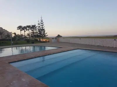 a swimming pool with blue water in a yard at Evasion Bouznika أمام شاطىء بوزنيقة in Bouznika