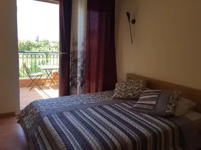 a bedroom with a bed with a view of a balcony at Bouznika Charly's in Bouznika
