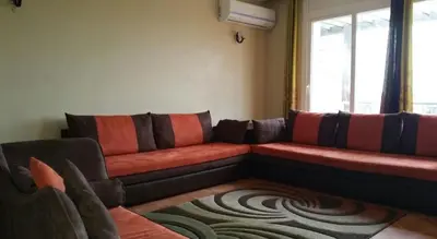 a living room with a couch and a window at Bouznika Charly's in Bouznika