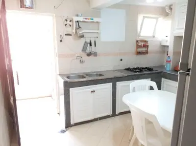 a kitchen with white cabinets and a white table at Villa Close To The Beach in Temara