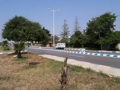 a road with blue and white stripes on the side at Villa Close To The Beach in Temara