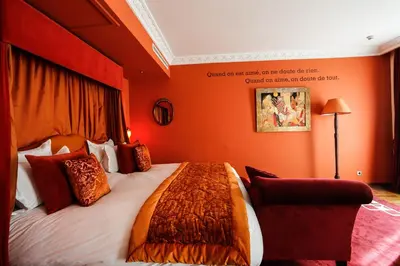 a bedroom with a large bed with orange walls at Hôtel particulier Le DOGE - Relais & Châteaux in Casablanca