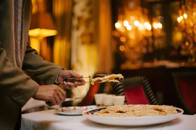 a person cutting a plate of food on a table at Hôtel particulier Le DOGE - Relais & Châteaux in Casablanca