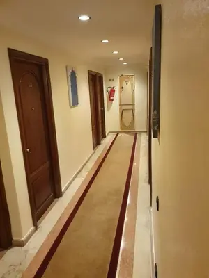 a hallway with a rug on the floor of a room at Hôtel Amouday in Casablanca