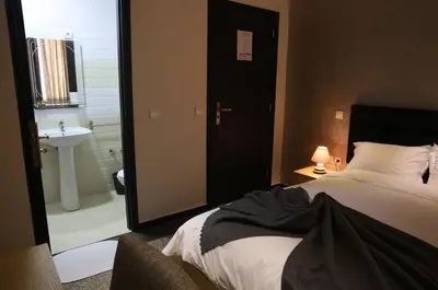 a bedroom with a bed and a bathroom with a sink at Point du Jour in Casablanca