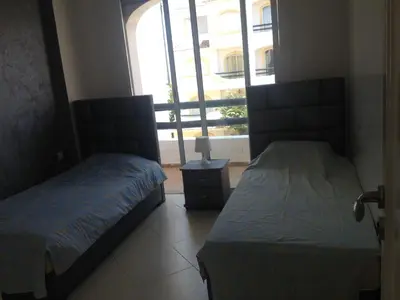 two beds in a room with a window at Garden Beach Sidi Rahal in Sidi Rahal