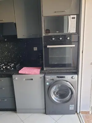 a kitchen with a washing machine and a microwave at Garden Beach Sidi Rahal in Sidi Rahal