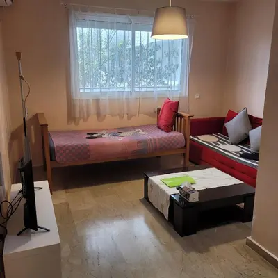a room with a bed and a couch and a window at Herb studio in Casablanca (800 m from Casavoyageurs station) in Casablanca