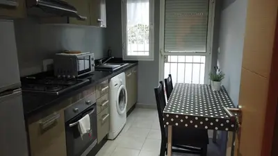 a kitchen with a stove and a table with a washing machine at Herb studio in Casablanca (800 m from Casavoyageurs station) in Casablanca