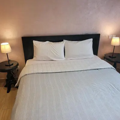 a bedroom with a bed with white pillows and two lamps at Herb studio in Casablanca (800 m from Casavoyageurs station) in Casablanca
