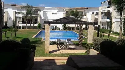 a swimming pool with a gazebo next to a building at Les perles de tamaris dar bouazza in Dar Mohammed Ould Haj Jilali