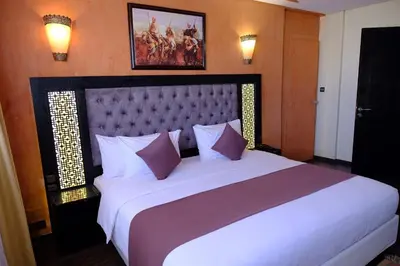 a bedroom with a large white bed with purple pillows at Washington Hotel in Casablanca