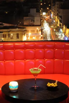 a red booth with a drink on a table at Washington Hotel in Casablanca