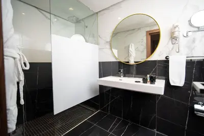 a bathroom with a sink and a mirror at Oum Palace Hotel & Spa in Casablanca