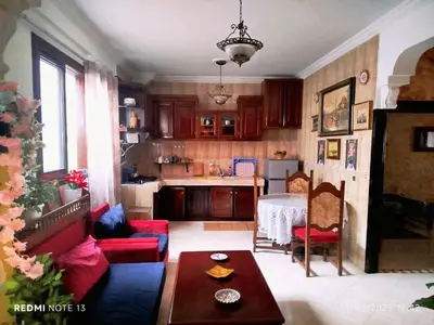 a living room with a table and a kitchen at Marguerite Apartemnt dans une résidence familiale in Casablanca