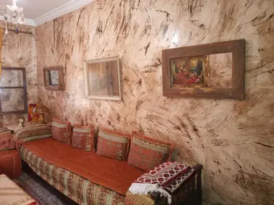 a living room with a couch and paintings on the wall at Marguerite Apartemnt dans une résidence familiale in Casablanca
