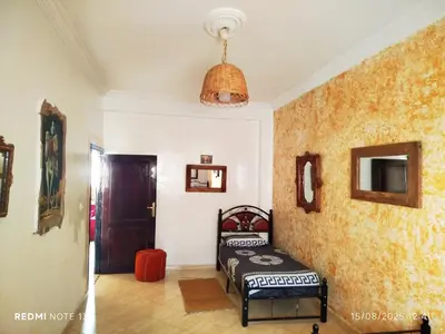 a bedroom with a bed in the corner of a room at Marguerite Apartemnt dans une résidence familiale in Casablanca