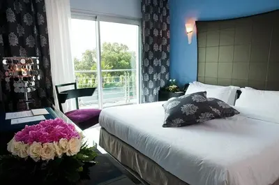a bedroom with a bed and a table with flowers on it at Avanti Mohammedia Hotel in Mohammedia