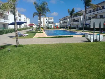 a swimming pool with a slide in a park at Marbella Beach Residency in Mansouria