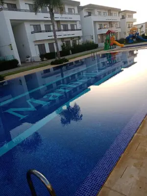 a swimming pool in front of a building at Marbella Beach Residency in Mansouria