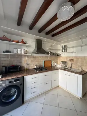 a kitchen with white cabinets and a washing machine at Appartement Casablanca Garden Beach in Casablanca