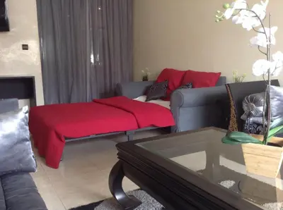a living room with a couch and a red blanket at Cosy Appartement Rabat Haut Agdal in Rabat