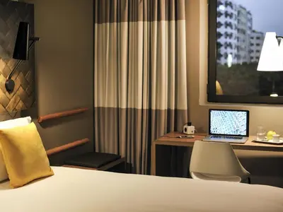 a hotel room with a bed and a desk with a laptop at Ibis Casa Voyageurs in Casablanca