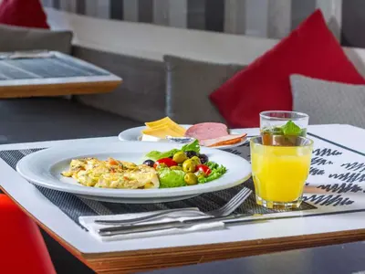 a table with a plate of food and a glass of orange juice at Ibis Casa Voyageurs in Casablanca