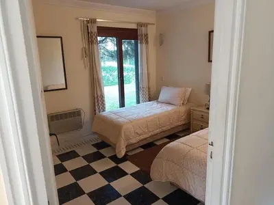 a bedroom with two beds and a checkered floor at Villa meublée face à la mer, Golf et Verdure in El Jadida