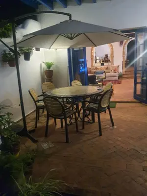 a table and chairs with an umbrella in a patio at Villa à Bouznika Bay-plage et golf in Bouznika