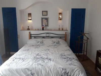 a bedroom with a bed with blue shutters at Villa à Bouznika Bay-plage et golf in Bouznika