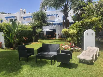 a group of chairs and a table in a yard at Villa à Bouznika Bay-plage et golf in Bouznika