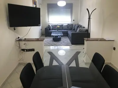 a living room with a couch and a flat screen tv at Résidence les Ambassadeurs in Rabat