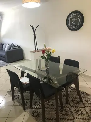a glass dining table and chairs in a living room at Résidence les Ambassadeurs in Rabat