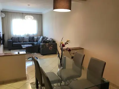a living room with a glass table and chairs at Résidence les Ambassadeurs in Rabat