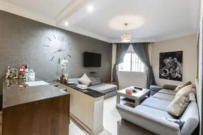 a living room with a large clock on the wall at Calm&cosy appart very well located in Casablanca