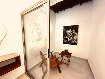 a glass room with a chair and a painting on the wall at Calm&cosy appart very well located in Casablanca