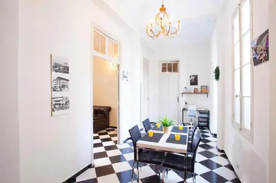 a dining room with a table and chairs on a checkered floor at appartement haussmannien centre ville Casablanca in Casablanca