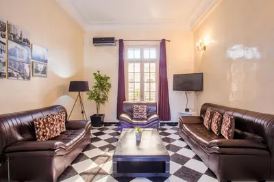 a living room with two leather couches and a tv at appartement haussmannien centre ville Casablanca in Casablanca