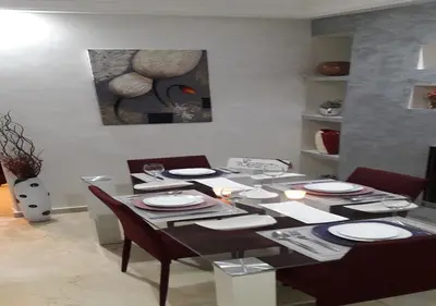 a dining room with a table with chairs and a painting at Horizon Garden Home in Casablanca