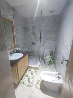 a bathroom with a shower and a toilet and a sink at appartments front mer in Bouznika