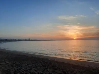 a sunset on a beach with the ocean at appartments front mer in Bouznika