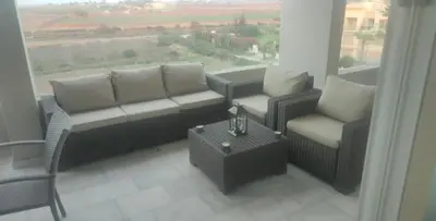a living room with a couch and chairs and a window at appartments front mer in Bouznika