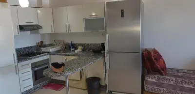 a kitchen with white cabinets and a refrigerator at Ola Blanca 1 in Dar Hamida